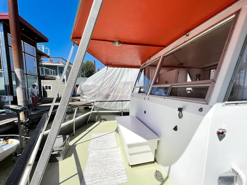 Slide: The Image of 1970 Tollycraft Tollyhome 36 boat deck with red canopy and docked surroundings. - 13