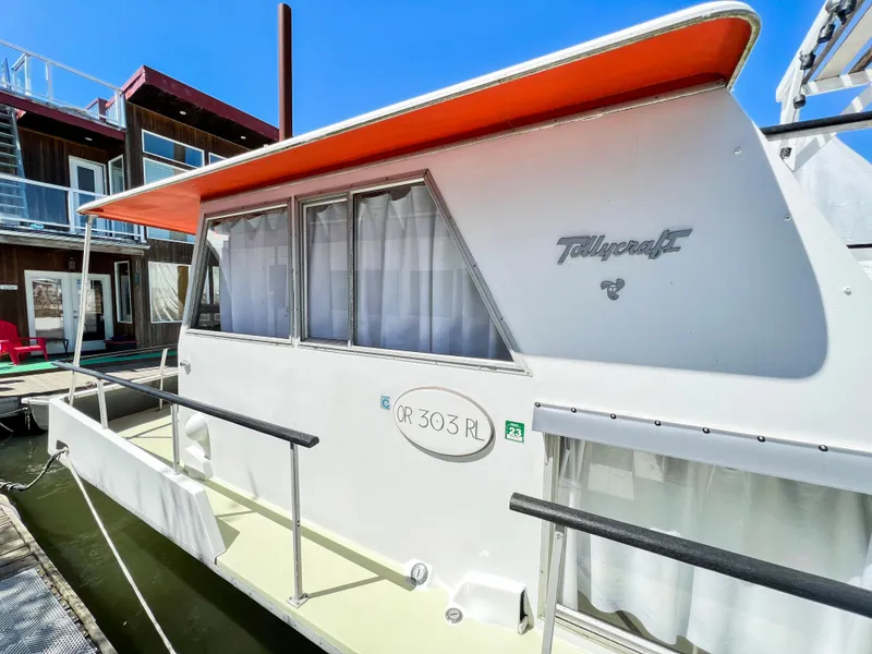 Slide: The Image of 1970 Tollycraft Tollyhome 36 houseboat with orange roof, docked beside modern building. - 14