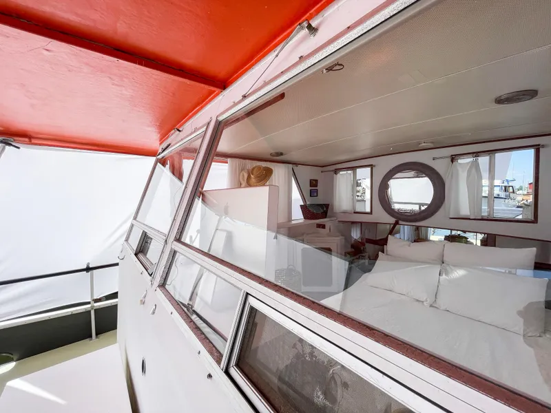 Slide: The Image of 1970 Tollycraft Tollyhome 36 interior with red canopy, white seating, and circular window. - 17