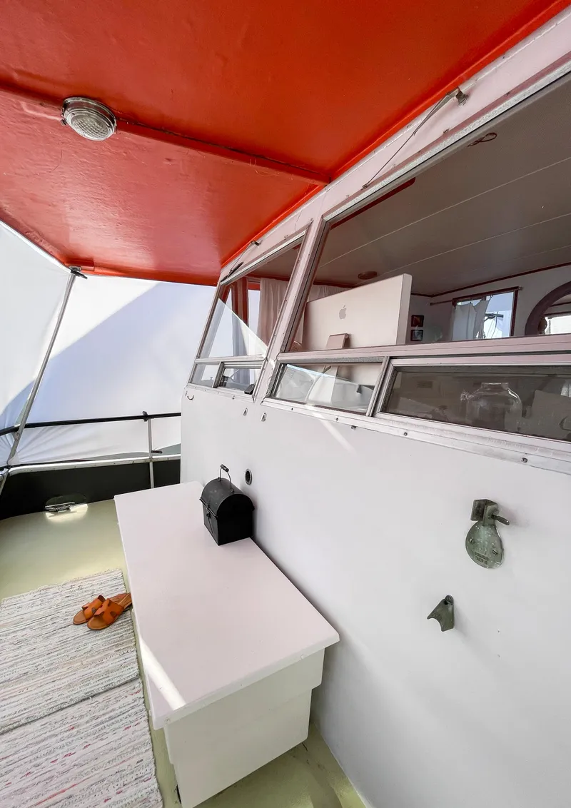 Slide: The Image of 1970 Tollycraft Tollyhome 36 boat interior with red canopy and white furnishings. - 18