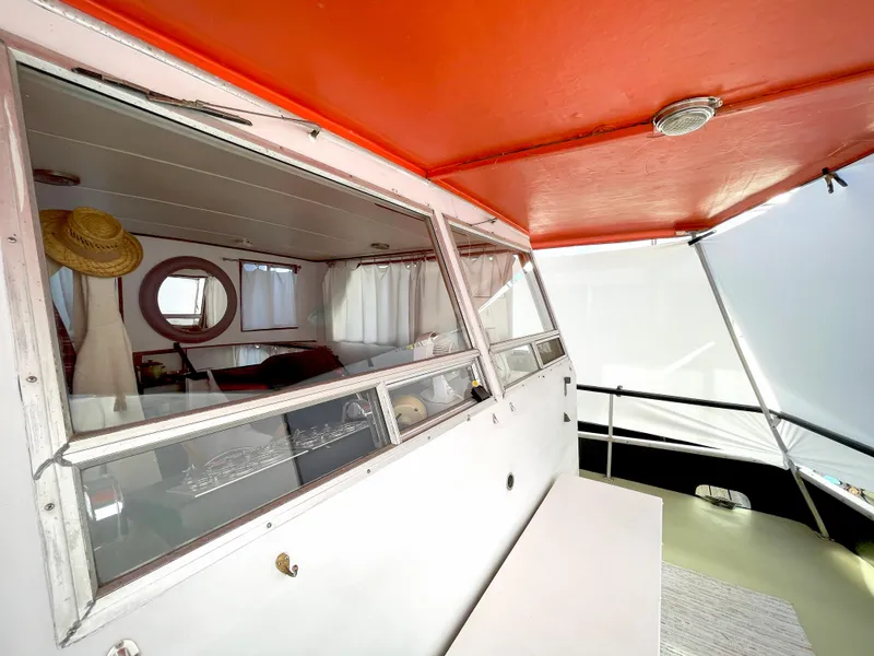 Slide: The Image of 1970 Tollycraft Tollyhome 36 boat interior with red ceiling and window view. - 19