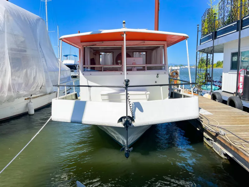Slide: The Image of 1970 Tollycraft Tollyhome 36 docked, front view, with bright orange canopy. - 2