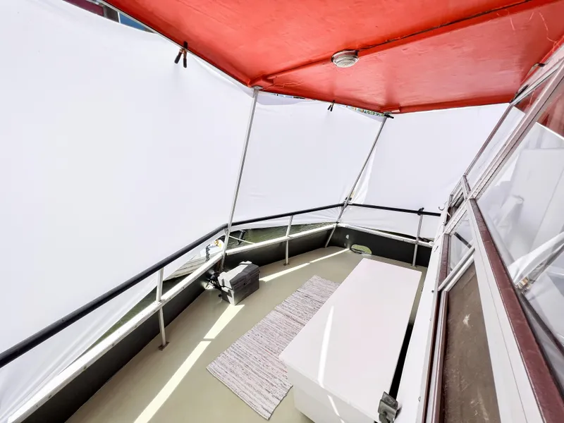 Slide: The Image of 1970 Tollycraft Tollyhome 36 boat deck with red canopy and white panels. - 20