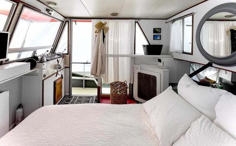 Slide: The Image of 1970 Tollycraft Tollyhome 36 interior with cozy bedroom, nautical decor, and natural light. - 22