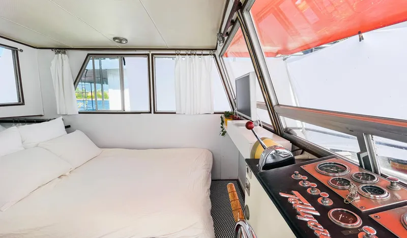Slide: The Image of 1970 Tollycraft Tollyhome 36 interior with bed, windows, and control panel. - 23