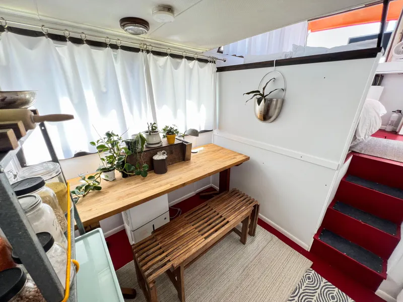 Slide: The Image of 1970 Tollycraft Tollyhome 36 interior with wooden table, plants, and red stairs. - 29