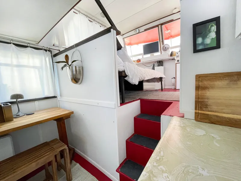 Slide: The Image of 1970 Tollycraft Tollyhome 36 interior with red stairs, wooden table, and cozy bedroom. - 30