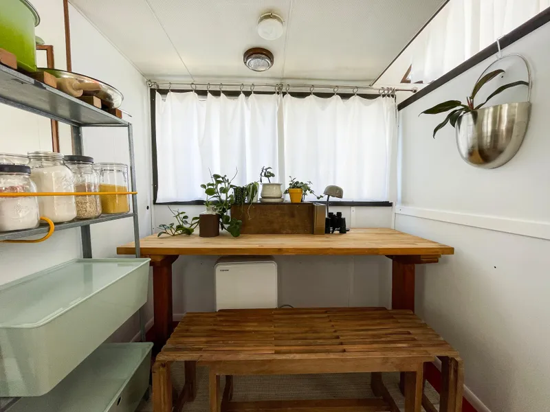 Slide: The Image of Tollycraft Tollyhome 36 interior with wooden table, plants, and storage shelves, 1970 model. - 32