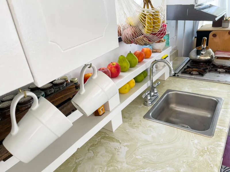 Slide: The Image of 1970 Tollycraft Tollyhome 36 kitchen with fruit, mugs, and sink on marble countertop. - 35