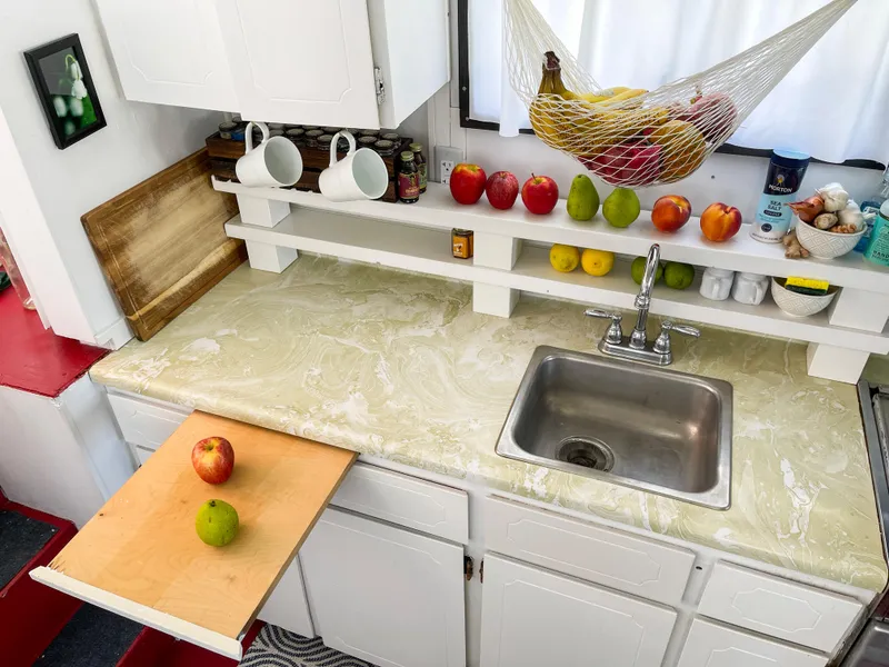 Slide: The Image of 1970 Tollycraft Tollyhome 36 kitchen with fruit, sink, and storage shelves. - 37