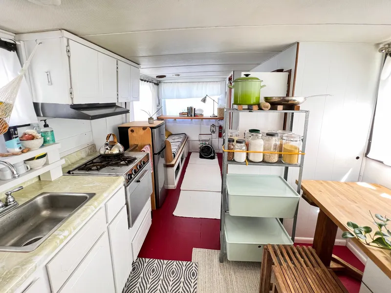 Slide: The Image of 1970 Tollycraft Tollyhome 36 interior with kitchen, dining area, and storage shelves. - 38