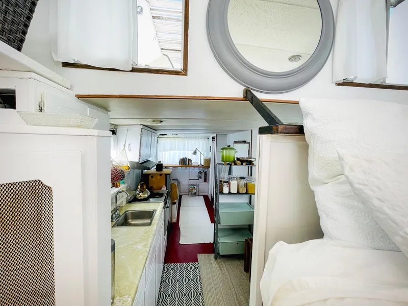 Slide: The Image of Interior of 1970 Tollycraft Tollyhome 36, featuring a compact kitchen and cozy living space. - 4