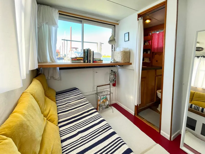 Slide: The Image of 1970 Tollycraft Tollyhome 36 interior with cozy seating, striped blanket, and window view. - 46