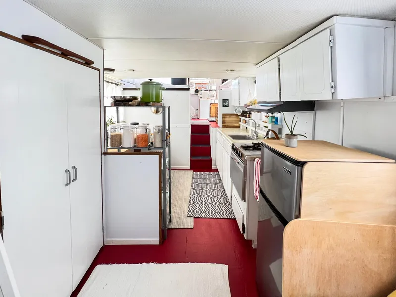 Slide: The Image of 1970 Tollycraft Tollyhome 36 interior with modern kitchen, red flooring, and white cabinetry. - 49