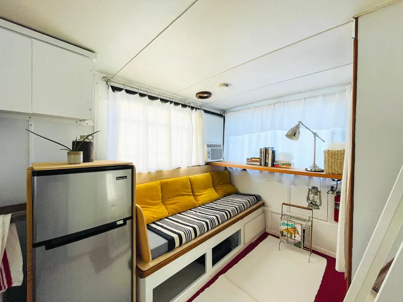 Slide: The Image of 1970 Tollycraft Tollyhome 36 interior with cozy seating, fridge, and stylish decor. - 8