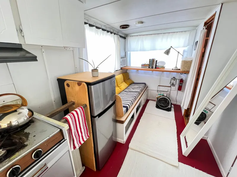 Slide: The Image of 1970 Tollycraft Tollyhome 36 interior with kitchenette, cozy seating, and nautical decor. - 9