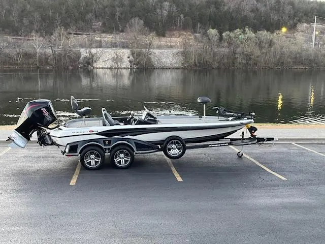 Slide: The Image of 2024 Ranger Z521R boat on trailer by a serene lake. - 0