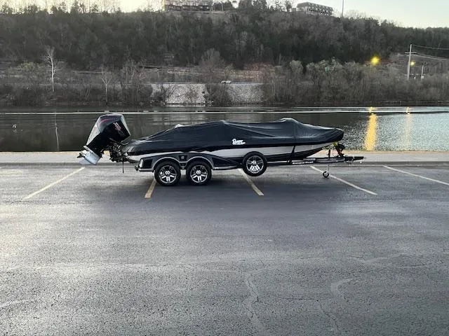 Slide: The Image of 2024 Ranger Z521R boat covered in parking lot near a river. - 5