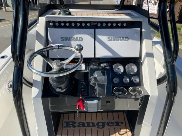 Slide: The Image of 2024 Ranger 2660 Bay boat dashboard with Simrad electronics and steering wheel. - 5