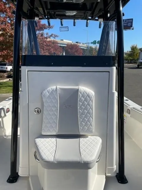 Slide: The Image of 2024 Ranger 2660 Bay boat with white cushioned seating and black frame. - 7