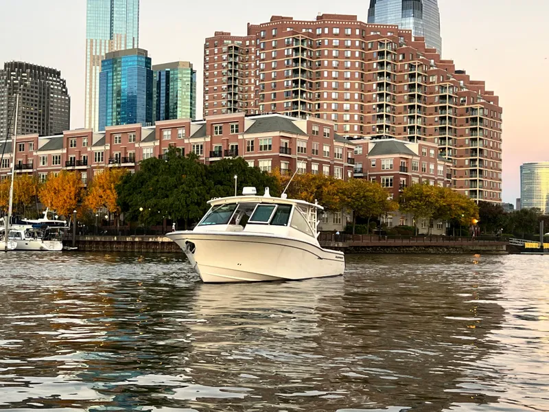 Slide: The Image of 2014 Grady-White Freedom 375 boat on water with cityscape background. - 2