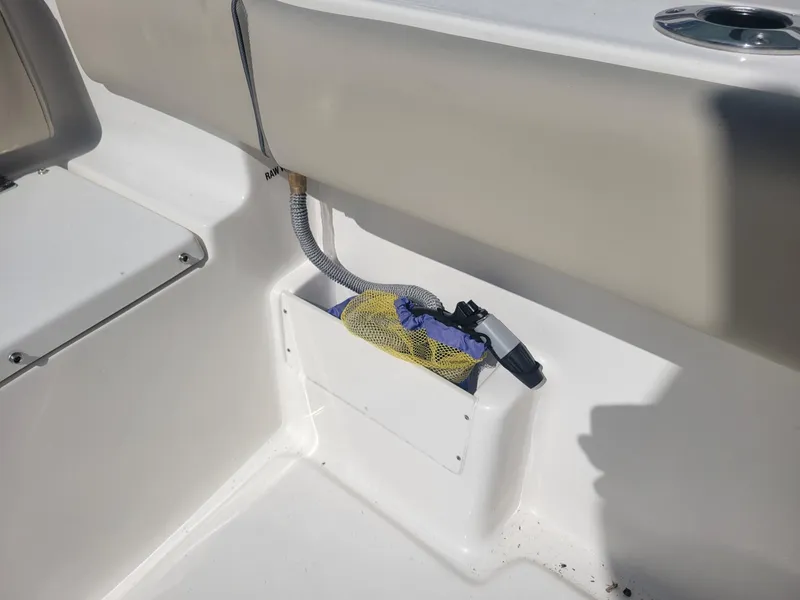Slide: The Image of 2024 Key West 239 FS boat interior storage compartment with hose and mesh bag. - 13