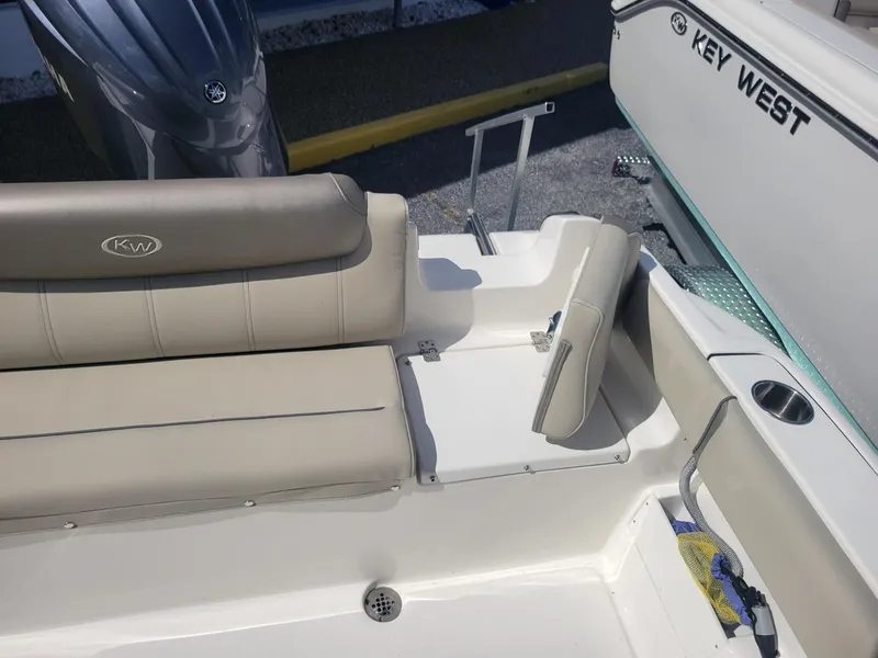 Slide: The Image of 2024 Key West 239 FS boat interior with beige seating and engine. - 14