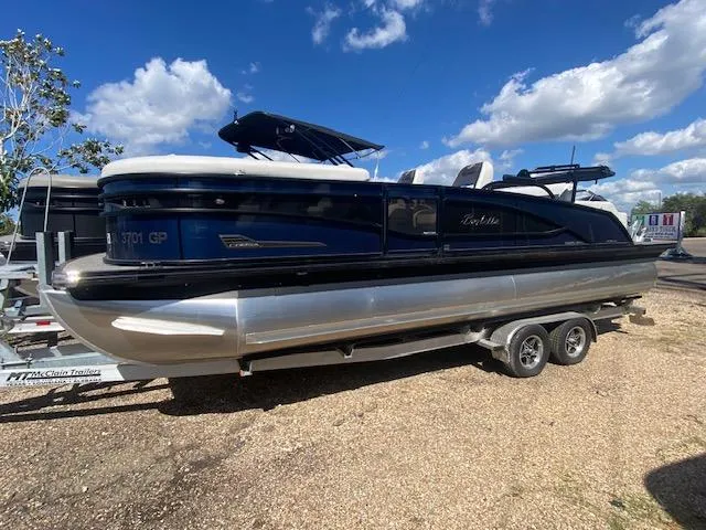 The Image of 2023 Barletta Corsa 23 UC pontoon boat on trailer under clear blue sky. - 0
