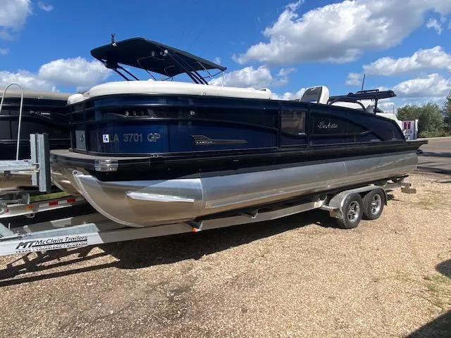 Slide: The Image of 2023 Barletta Corsa 23 UC pontoon boat on trailer, parked outdoors. - 3