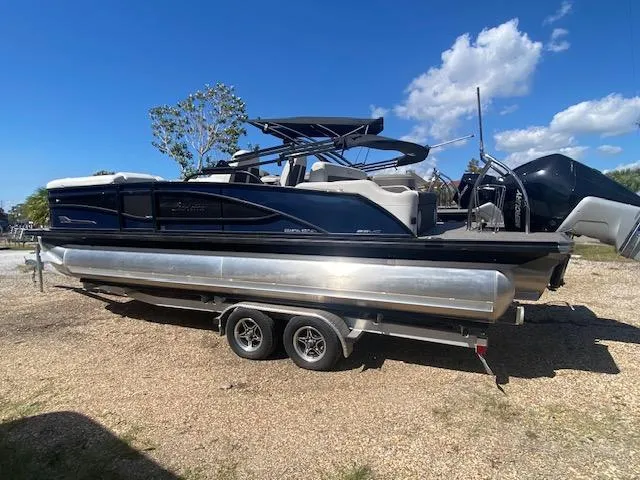 Slide: The Image of 2023 Barletta Corsa 23 UC pontoon boat on trailer outside a warehouse. - 4