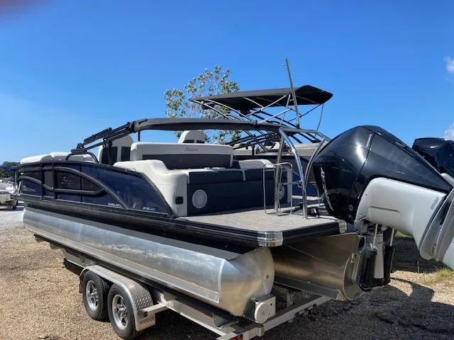 Slide: The Image of 2023 Barletta Corsa 23 UC pontoon boat on trailer, parked outside a warehouse. - 5