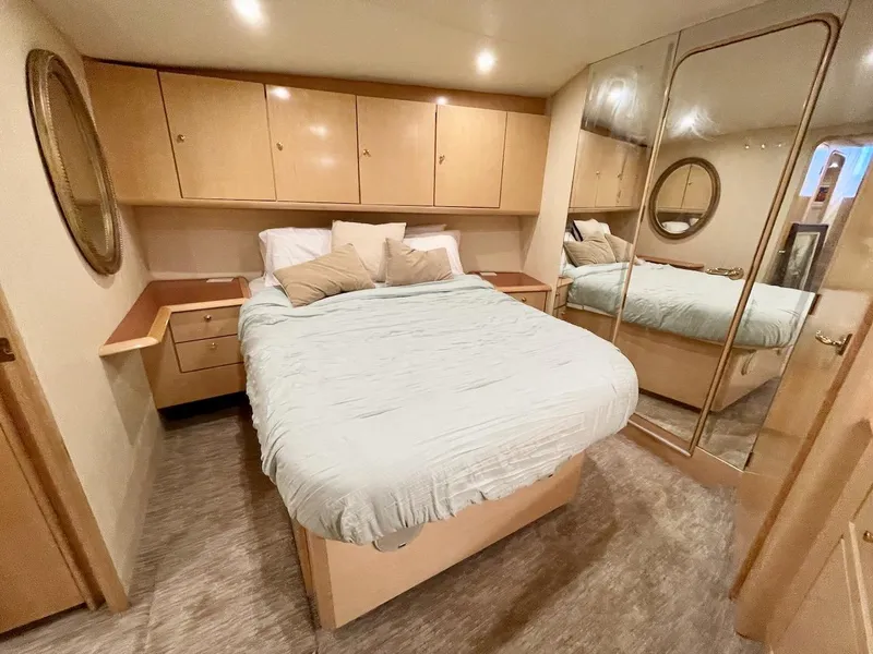 Slide: The Image of Luxurious bedroom in 2003 Ocean Yachts 62 Convertible with mirrored closet and ample storage. - 13