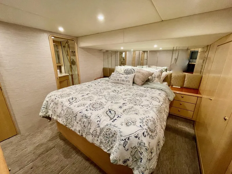 Slide: The Image of Luxurious bedroom in 2003 Ocean Yachts 62 Convertible with elegant bedding and ample storage. - 14