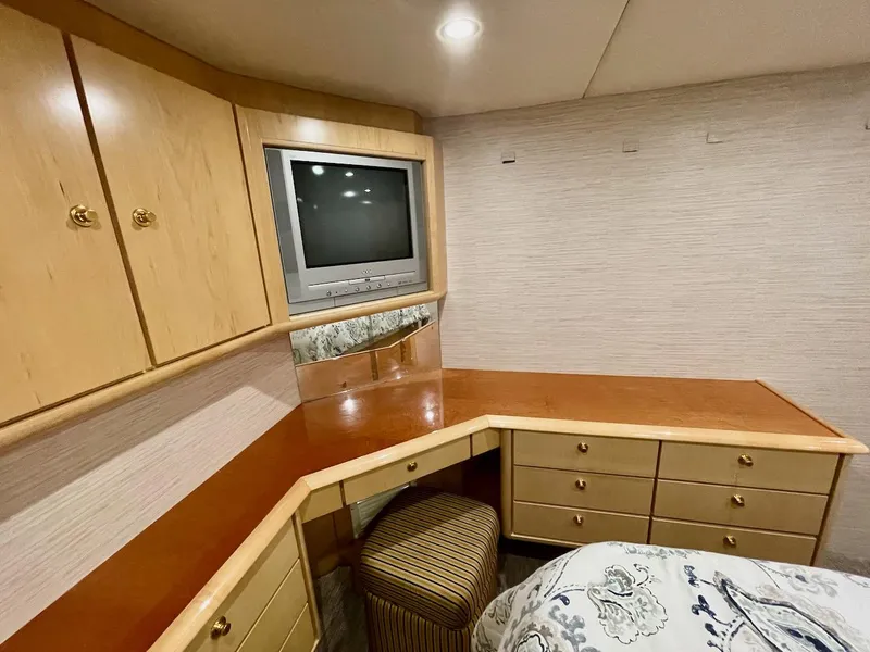 Slide: The Image of 2003 Ocean Yachts 62 Convertible cabin with TV, desk, and storage cabinets. - 17