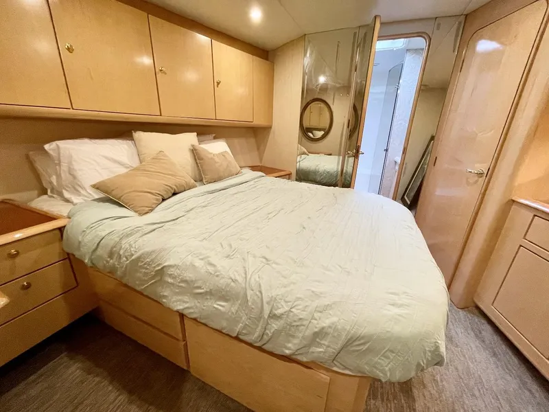 Slide: The Image of 2003 Ocean Yachts 62 Convertible bedroom with wooden cabinets and a cozy bed. - 19