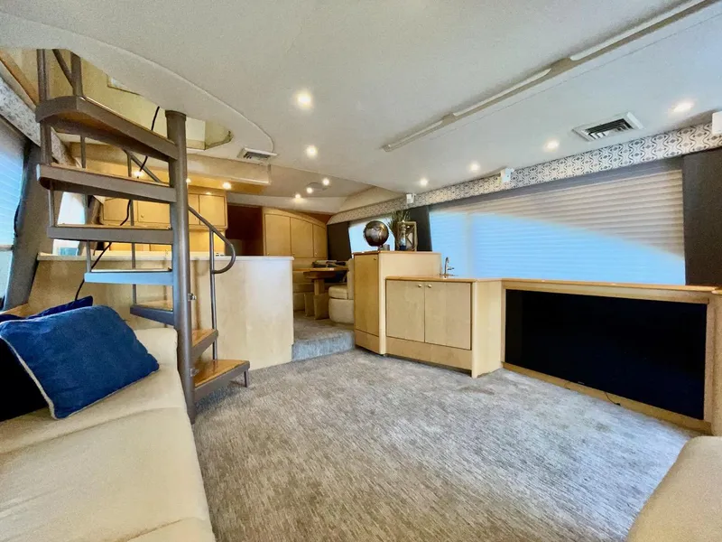 Slide: The Image of Spacious interior of 2003 Ocean Yachts 62 Convertible with modern furnishings and spiral staircase. - 2