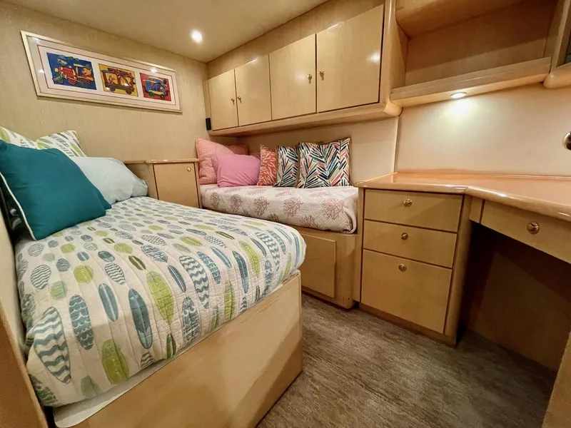 Slide: The Image of 2003 Ocean Yachts 62 Convertible cabin with twin beds, storage cabinets, and desk. - 23