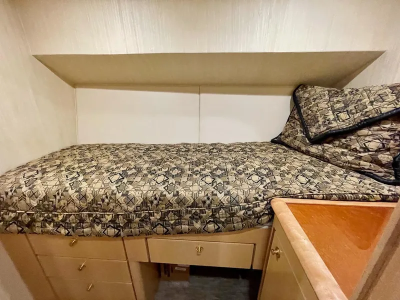 Slide: The Image of 2003 Ocean Yachts 62 Convertible cabin with patterned bedding and storage drawers. - 28