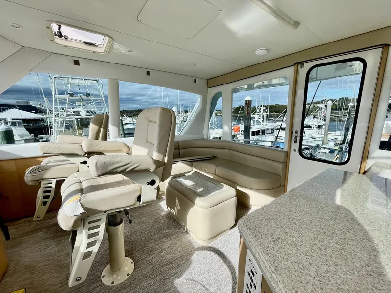 Slide: The Image of 2003 Ocean Yachts 62 Convertible interior with helm chairs and marina view. - 31