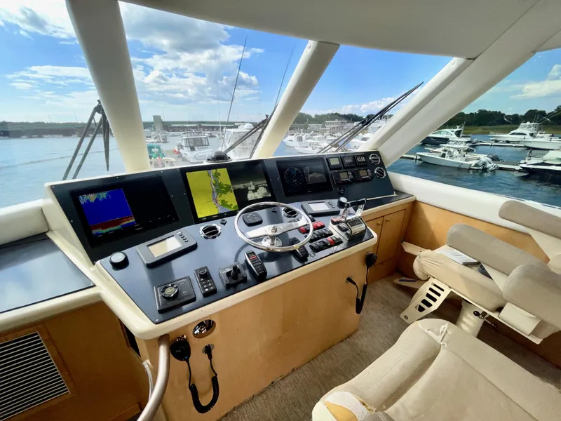 Slide: The Image of 2003 Ocean Yachts 62 Convertible helm with navigation screens and marina view. - 34