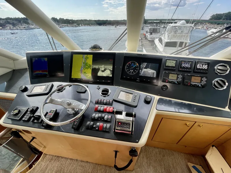 Slide: The Image of 2003 Ocean Yachts 62 Convertible helm with navigation screens and controls, overlooking marina. - 35