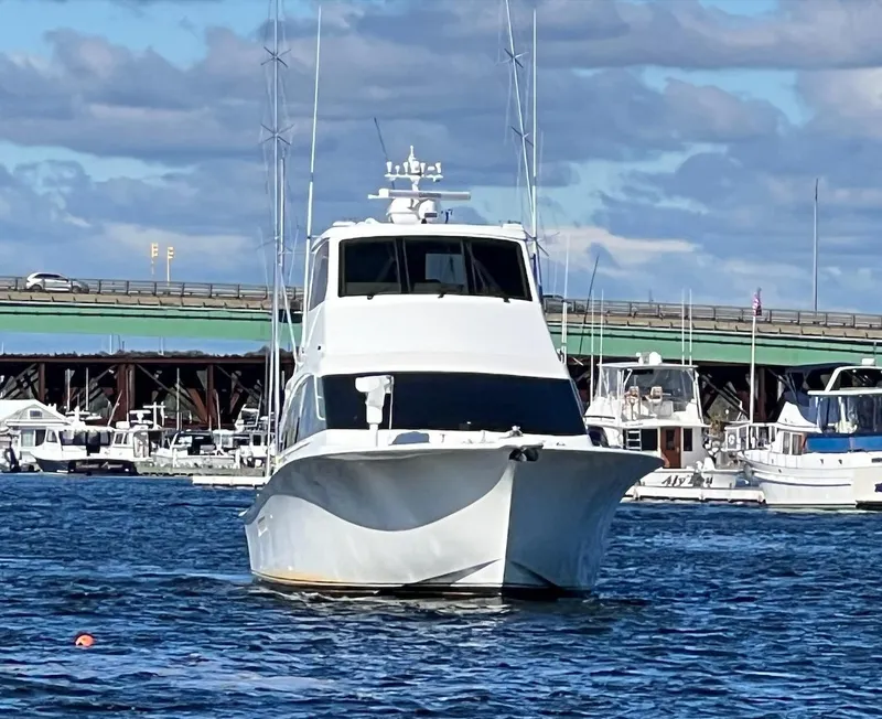 Slide: The Image of 2003 Ocean Yachts 62 Convertible in a marina with a bridge in the background. - 46