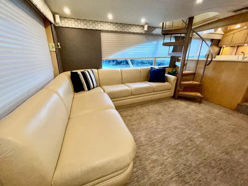 Slide: The Image of Luxurious interior of 2003 Ocean Yachts 62 Convertible with beige leather sofa and spiral staircase. - 5