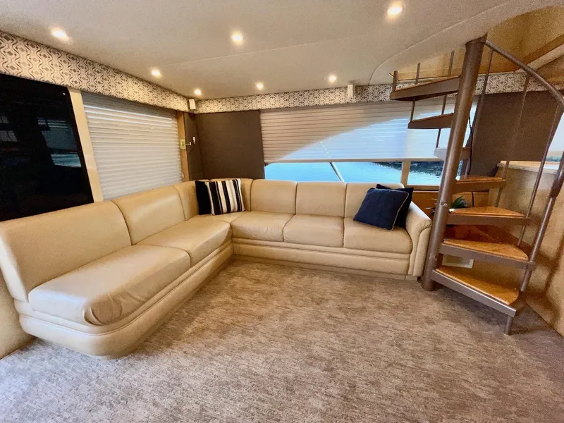 Slide: The Image of Luxurious interior of a 2003 Ocean Yachts 62 Convertible with beige leather seating and spiral staircase. - 6