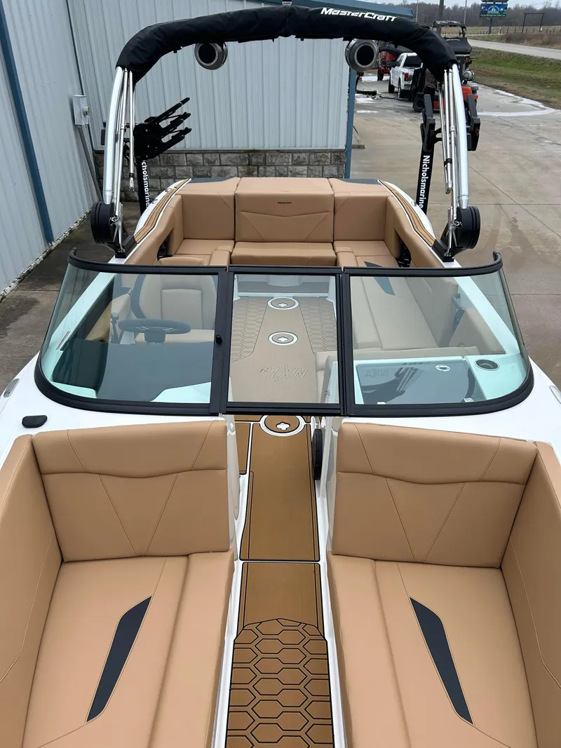Slide: The Image of 2024 MasterCraft NXT 24 boat with tan interior and black accents. - 12