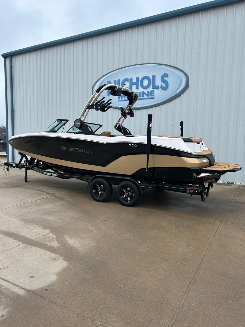 Slide: The Image of 2024 MasterCraft NXT 24 boat on trailer outside Nichols Marine. - 2