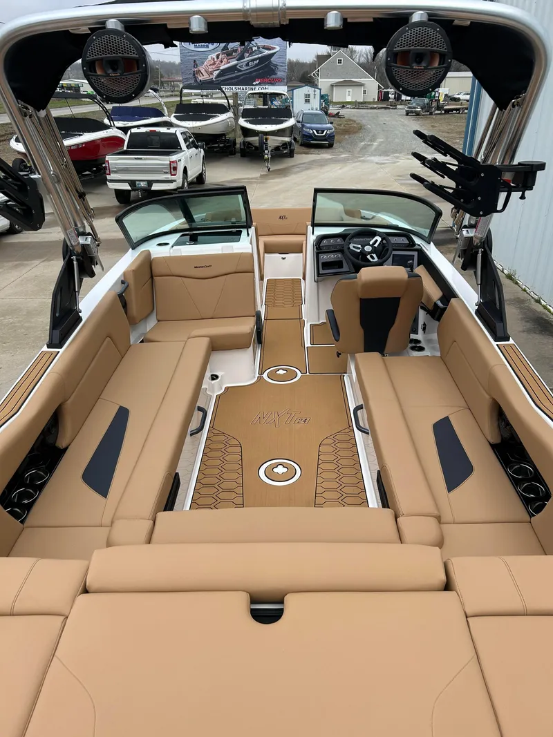 Slide: The Image of 2024 MasterCraft NXT 24 boat interior with tan seating and modern dashboard. - 5