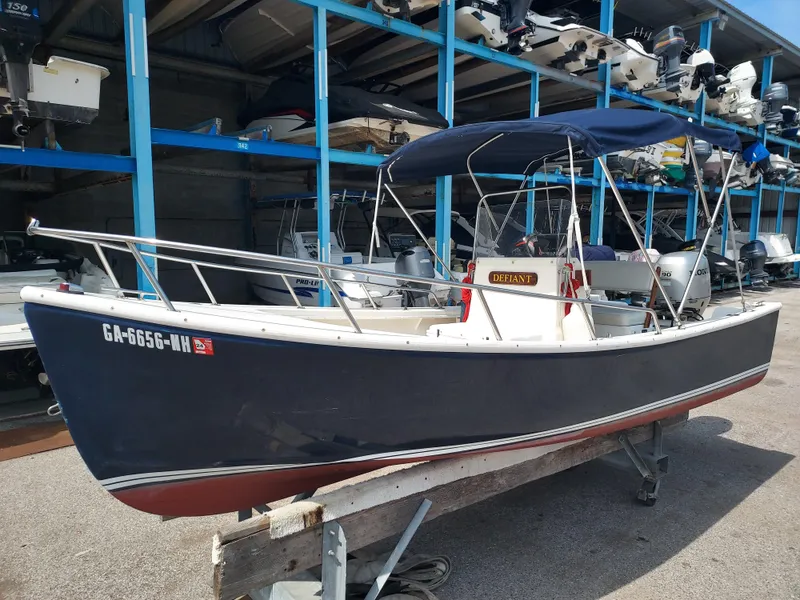 Slide: The Image of 2000 Eastern 19 Center Console boat in storage, blue hull, named Defiant. - 2