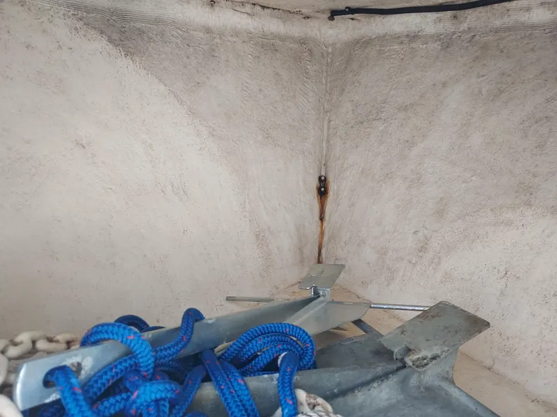 Slide: The Image of Anchor and blue rope in the storage compartment of a 2000 Eastern 19 Center Console boat. - 46