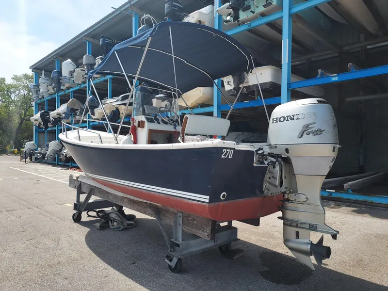 Slide: The Image of 2000 Eastern 19 Center Console boat with Honda outboard motor in storage facility. - 25